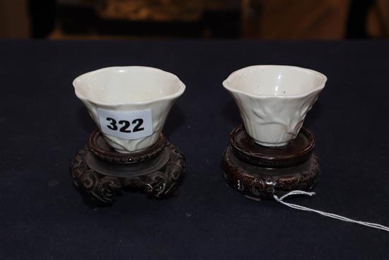 A pair of 18th century Chinese blanc de chine libation cups, wood stands